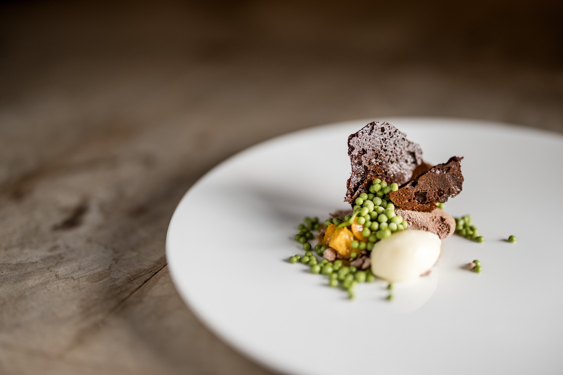 Dessert mit aus Valrhona-Schokolade, Kapstachelbeere und Petersilie von „Patissier des Jahres 2025“ Jakob Szedonja Dessert mit aus Valrhona-Schokolade, Kapstachelbeere und Petersilie von „Patissier des Jahres 2025“ Jakob Szedonja